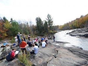 Faculty member teaching class by a stream