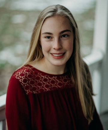 Headshot of Amy Francesconi, with long, straight dirty-blonde hair and a wearing garnet-colored blouse.