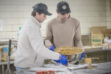 Two members of Campus Kitchens helping to prepare a meal